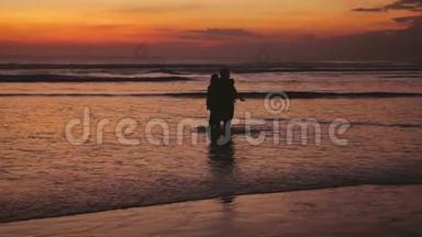 美丽的夕阳下，幸福的家庭在海上漫步。 慢动作。 3840x2160